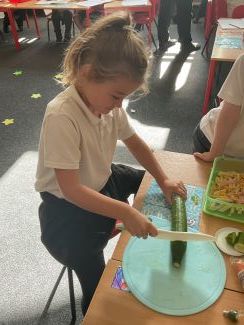 Child chopping a cucumber