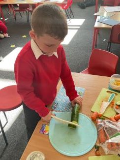 Child chopping a cucumber