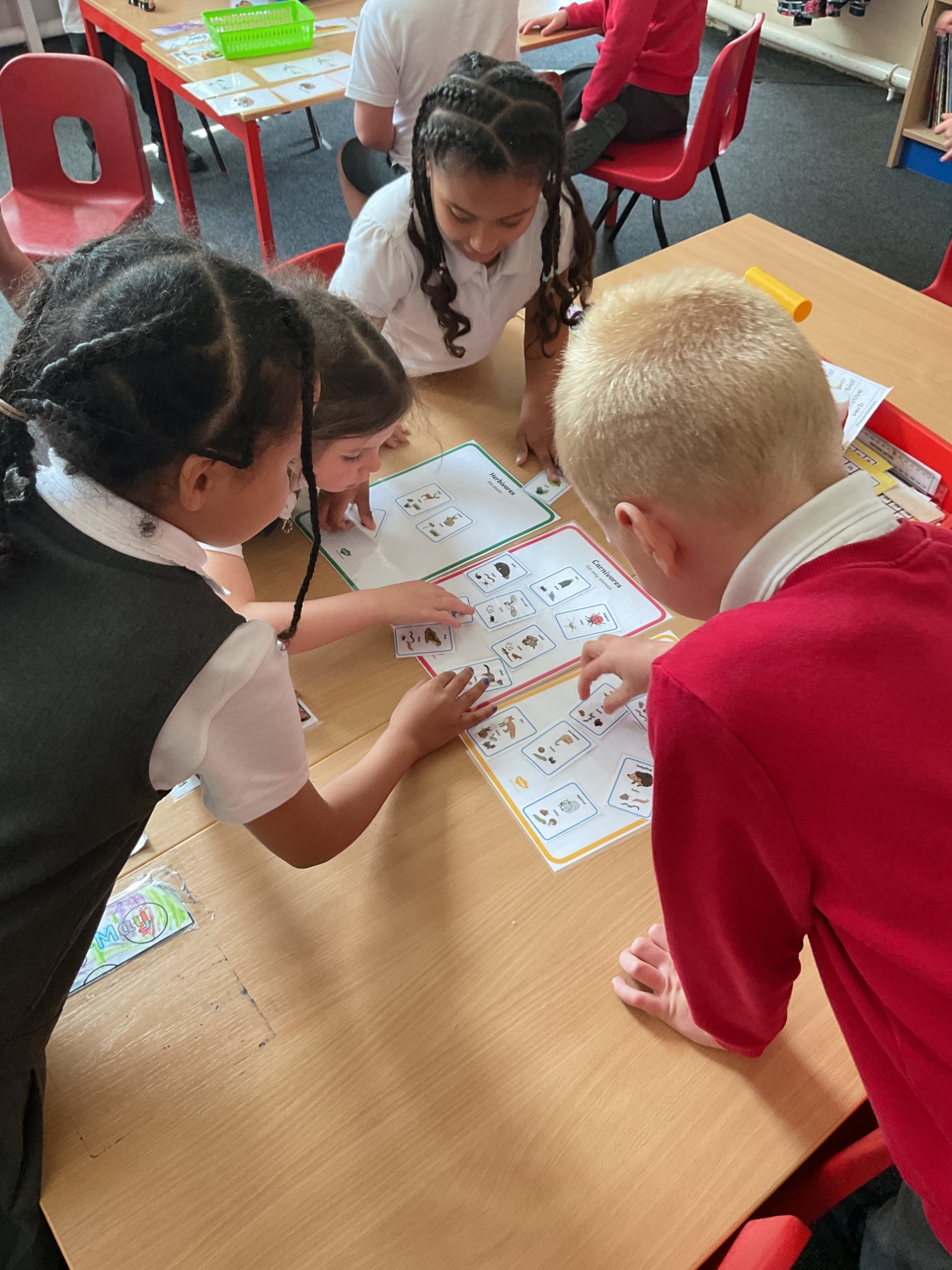children looking at pictures around a table