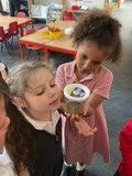 children looking at jar of caterpillars